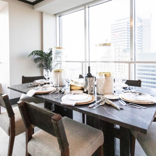 Beautiful living spaces with natural lighting a dining room surrounded by large windows and city views